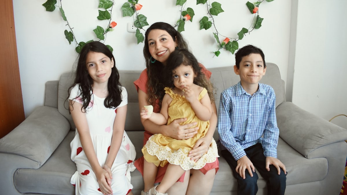 a group of people sitting on a couch posing for the camera
